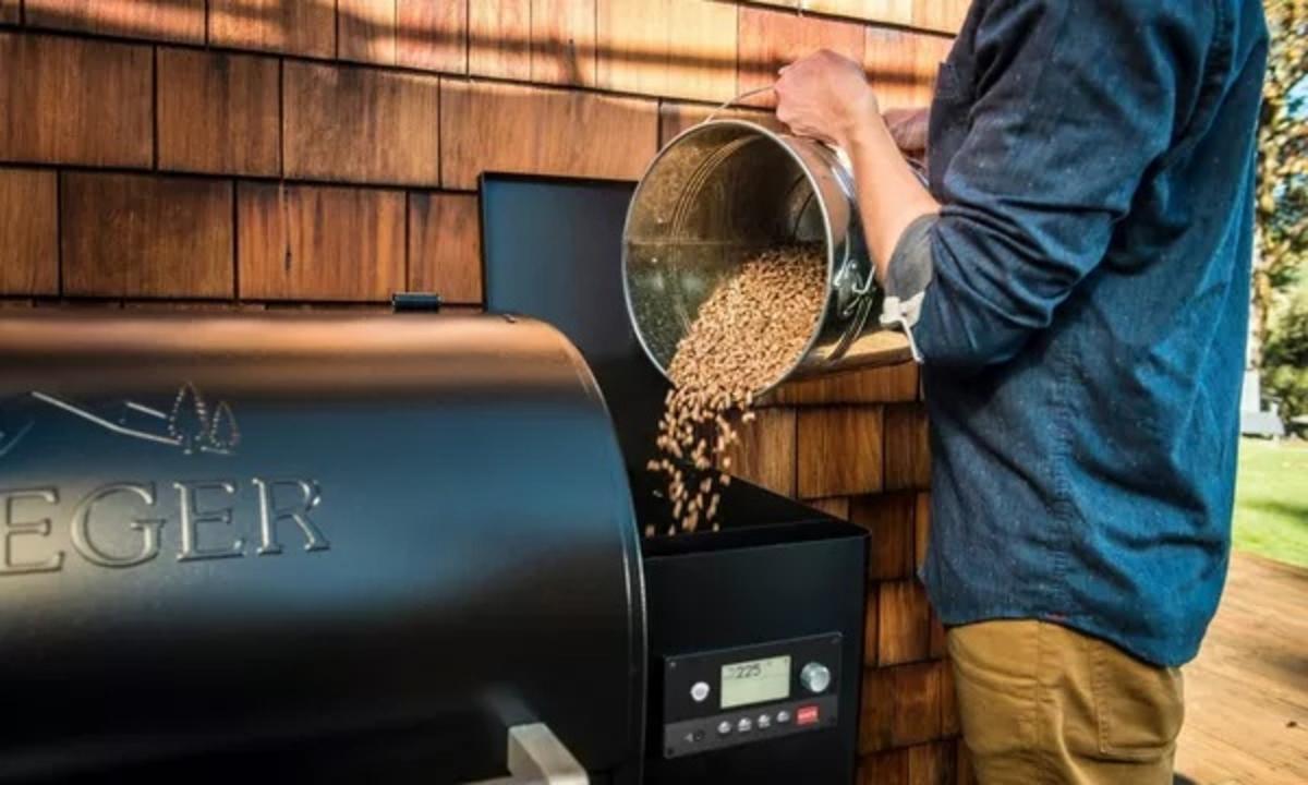 Man adding pellets to a Traeger